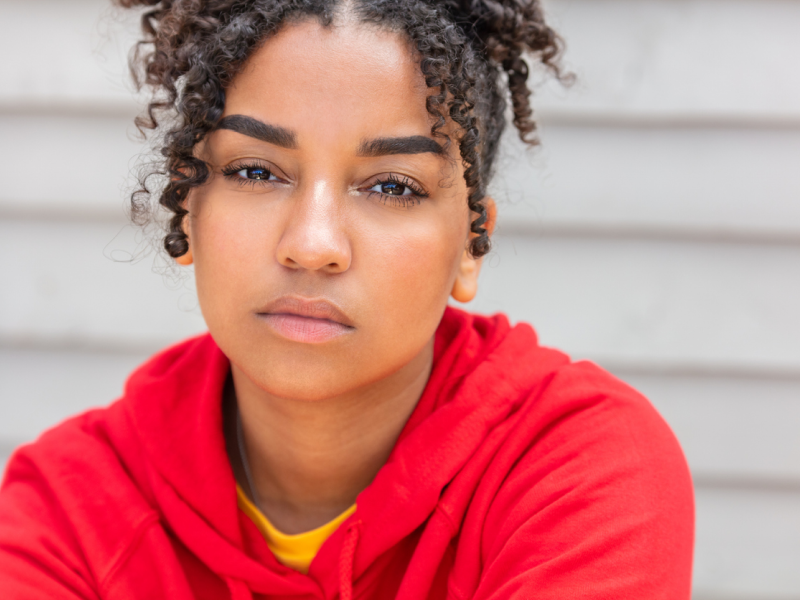 A teenager in a red sweatshirt has 5 mental health red flags that are common in teens and adolescents.