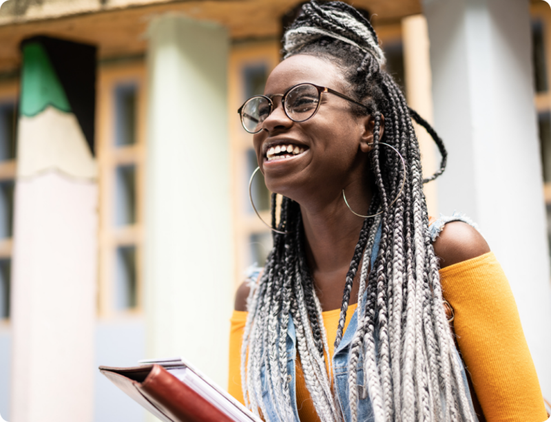 A student with a dissociative disorder smiles with a notebook