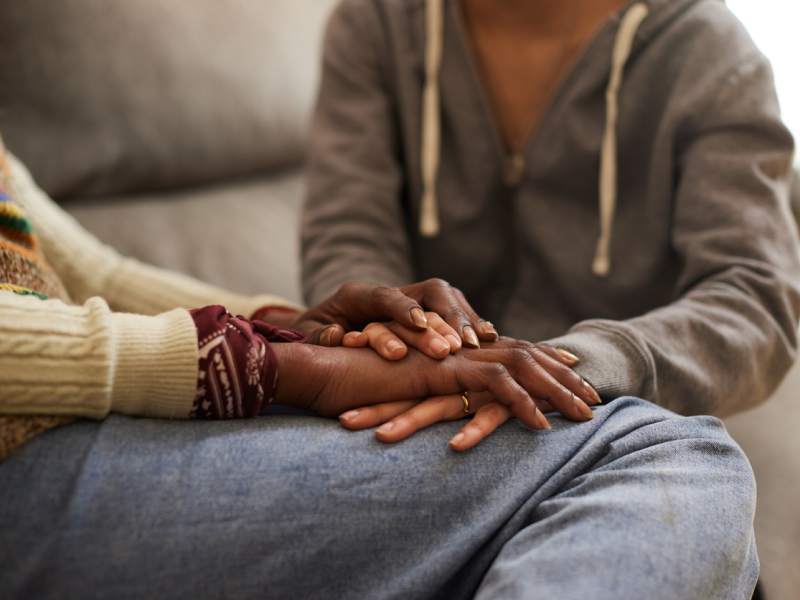 A mother holds the hand of her daughter who is healing from sexual trauma.