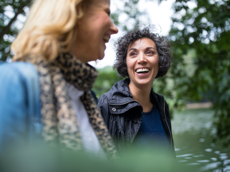 A woman is with her friend on a walk talking about pink cloud syndrome.