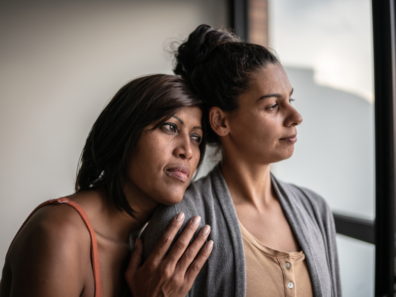 A woman hugs her partner who is living with bipolar disorder.