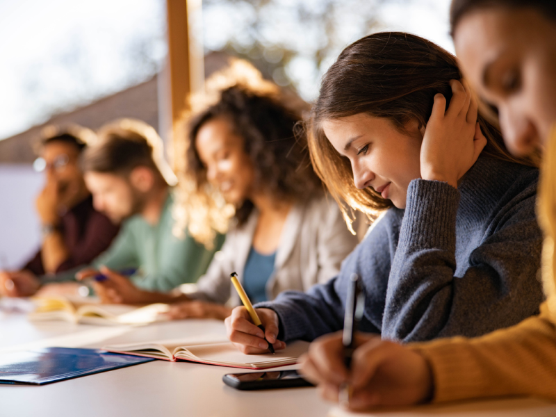 High school students sit at their desk working on school work. They are experiencing how mental health issues make school harder.