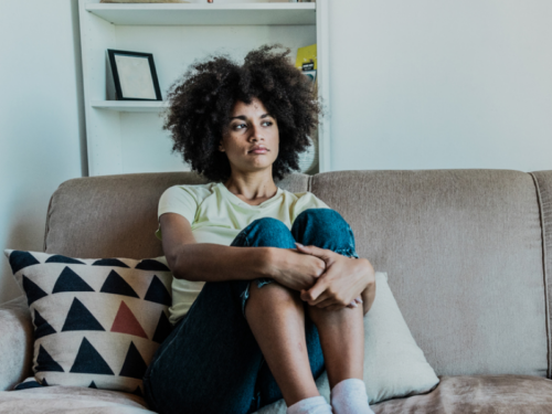 A woman who has cannabis use disorder sits on her couch.