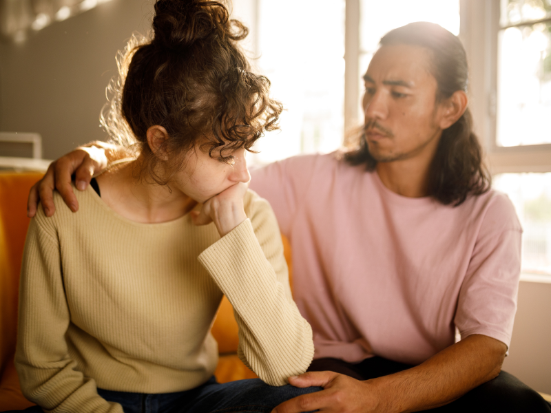 A man comforts his partner who is experiencing alcohol-induced psychosis.