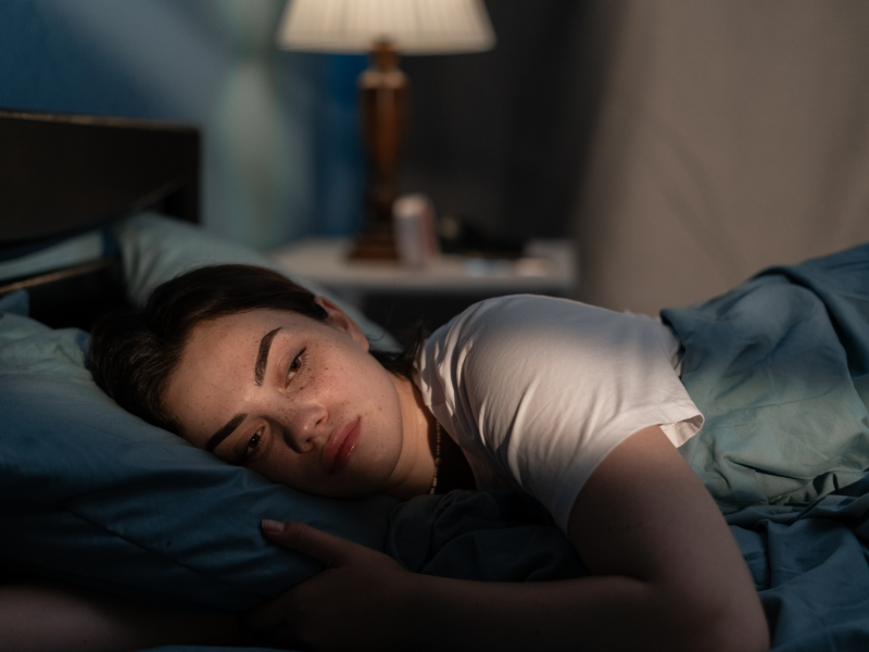 A woman lays in bed after experiencing anxiety tics.