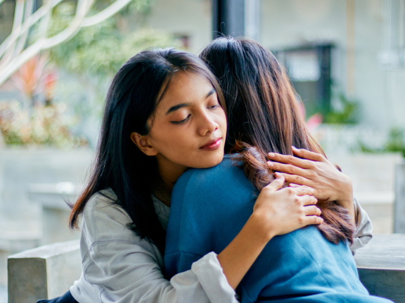 A woman gives a hug and supports her friend who is suicidal.