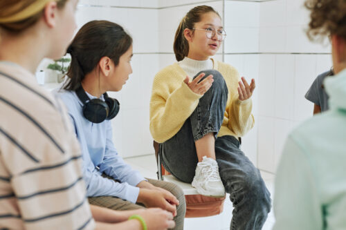 Portrait of teenage girl recovering from substance use sharing feelings in a group therapy circle