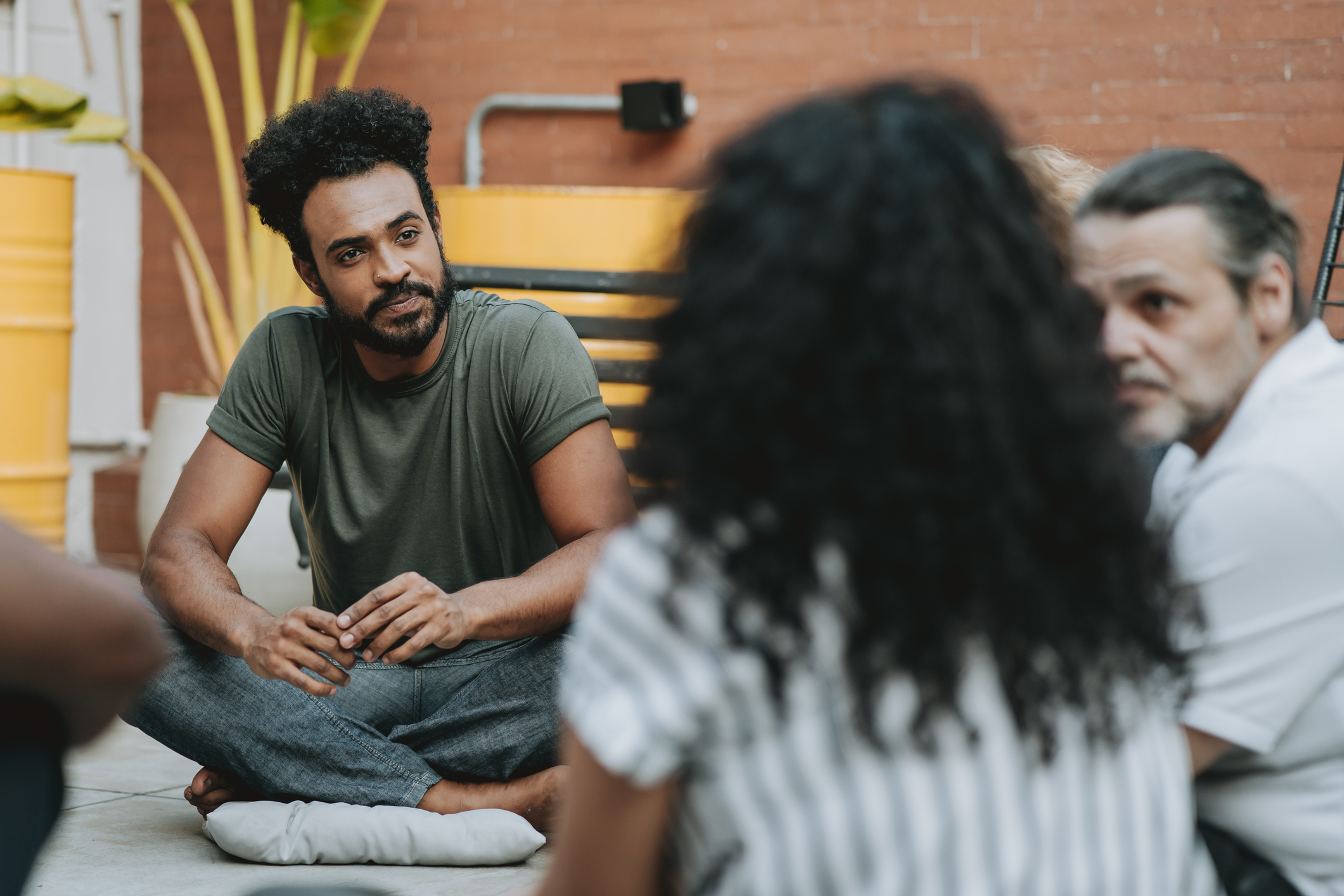 Man listening to provide emotional support to a woman struggling with substance use in group therapy.