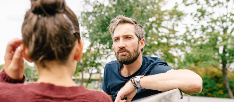 A woman sits with her father who is abusive.