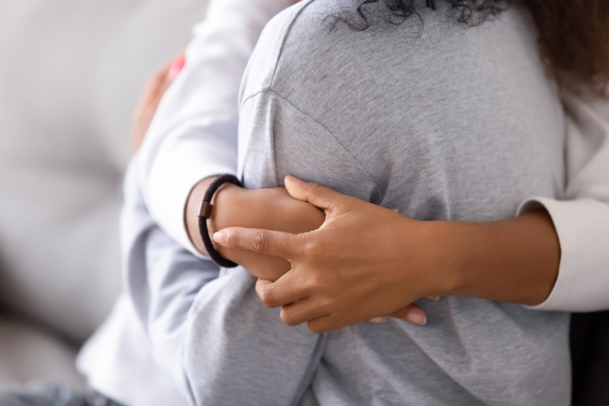 Two individuals embracing in a comforting hug, symbolizing support and connection during a challenging time, such as coping with the emotional impact of divorce.