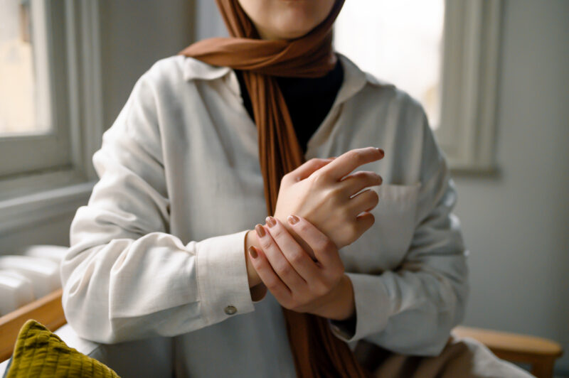 Woman tending to cut or bruise on wrist.