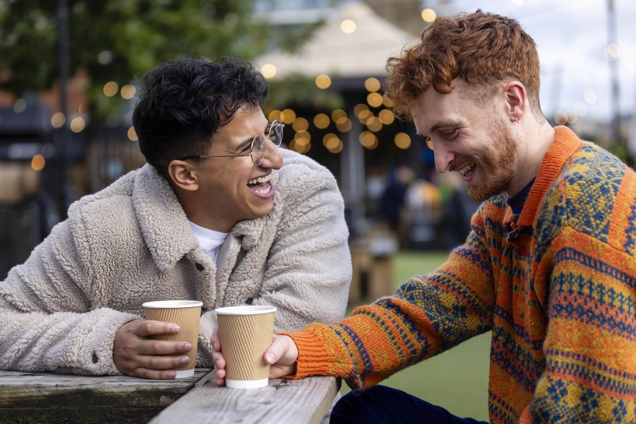 Two men on their date together. They are laughing and lighter.