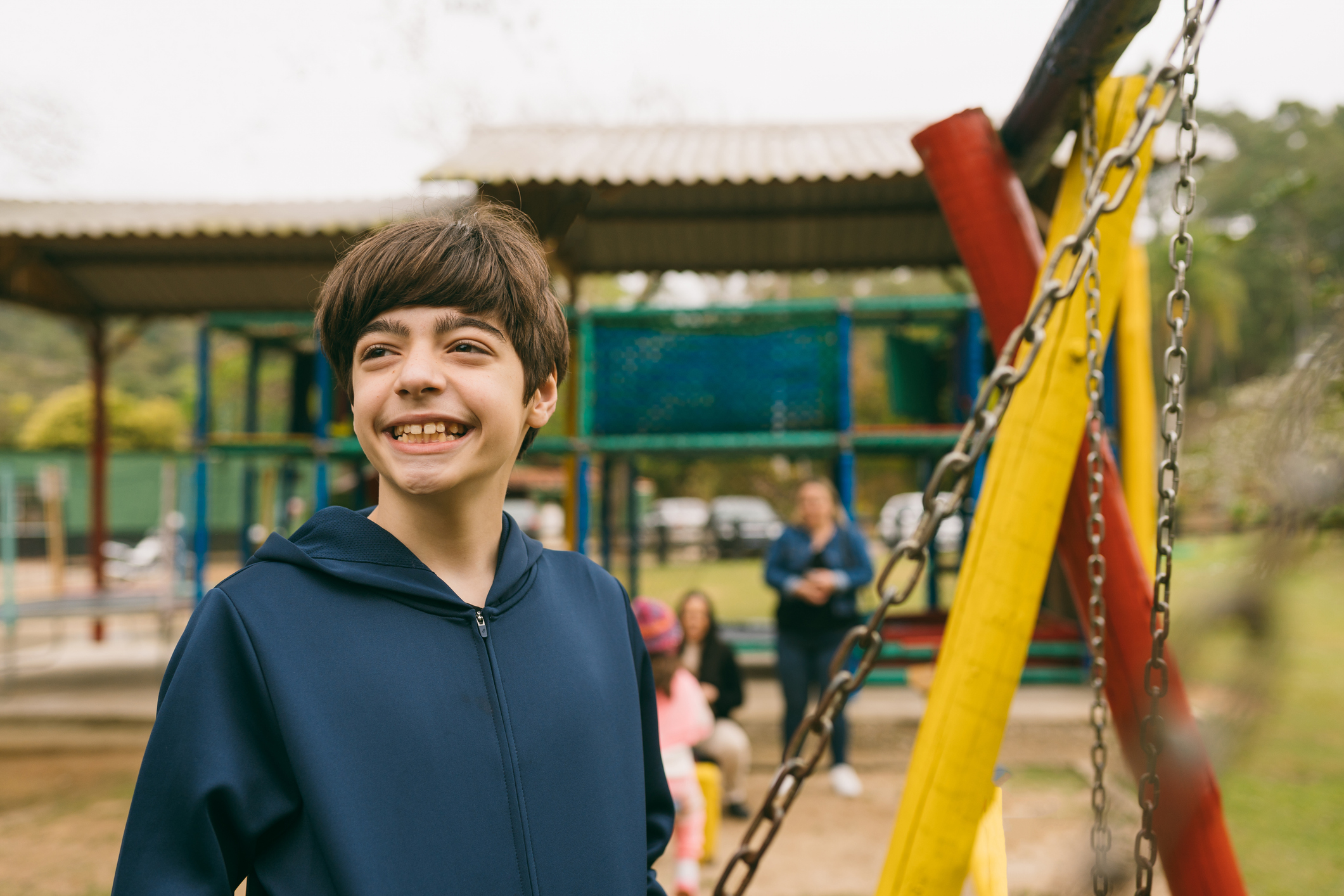 Preteen boy smiling on playground after addressing his anxiety