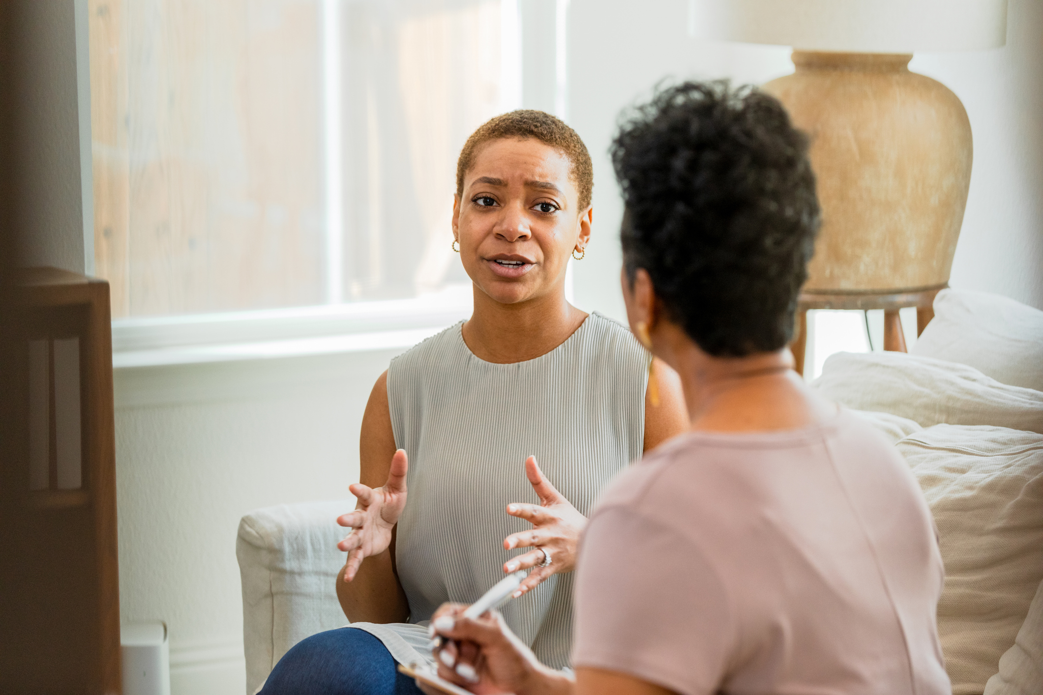 Woman talking to a therapist about her alcoholism.